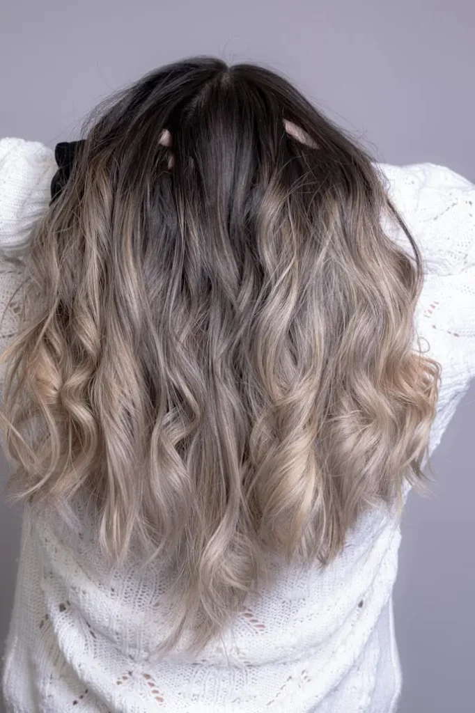 Model showcasing a custom dimensional color with blended highlights and a soft shadow root, demonstrating