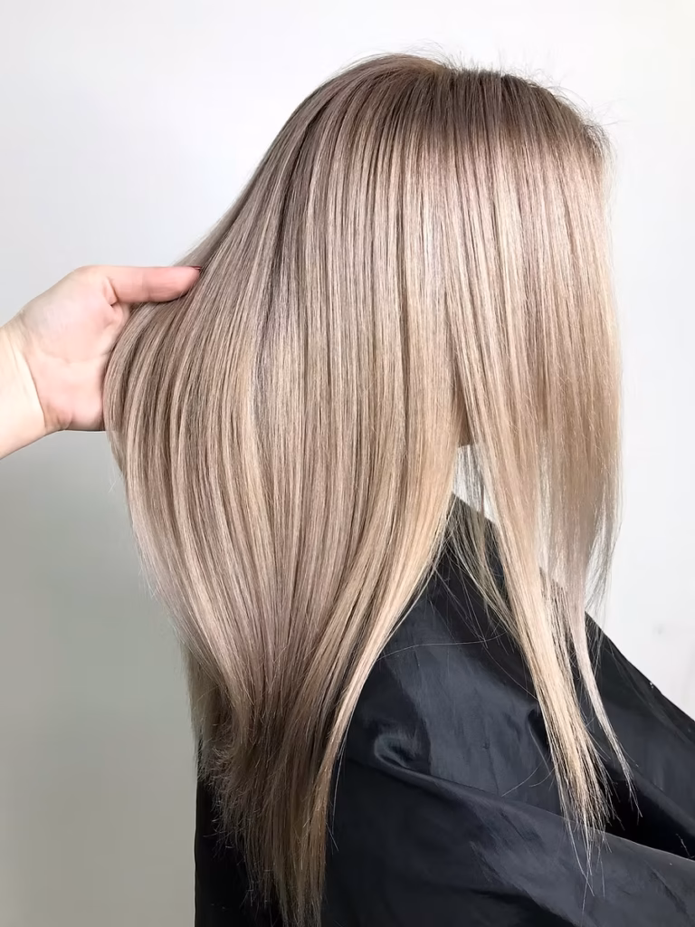 Blonde hair styled with smooth, sleek layers, showcasing a polished look ideal for special occasions