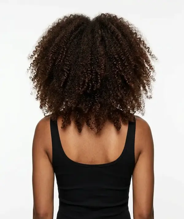 Close-up view of curly, dark brown hair styled with reduced frizz, showcasing results from Keratin